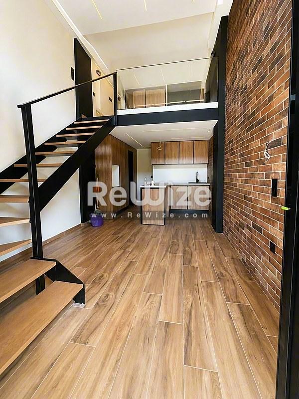 Ανοιχτό loft στη Χαλκιδική με υπνοδωμάτιο σε μεζονέτα, ξύλινα δάπεδα και τούβλινες λεπτομέρειες.