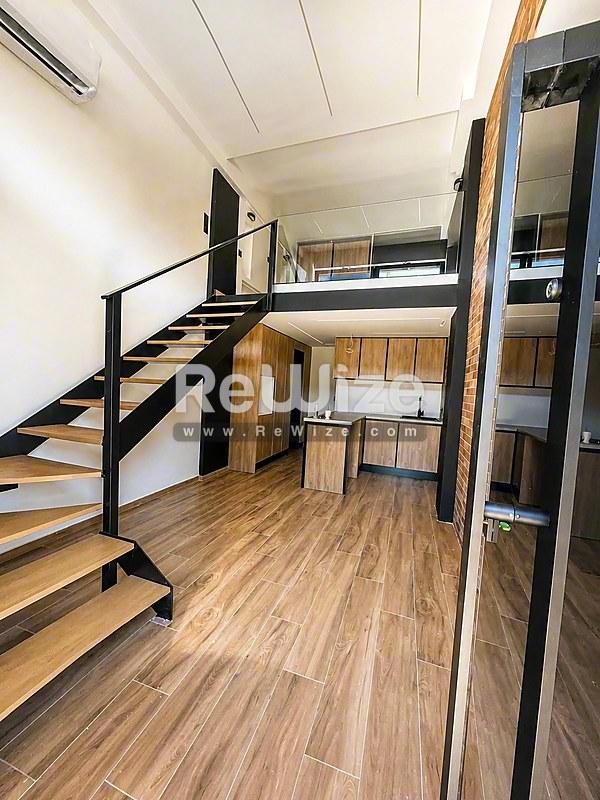 Μικρό σπίτι ανοιχτής διαρρύθμισης στη Χαλκιδική με ενσωματωμένο δωμάτιο-σοφίτα, κουζίνα και αποθήκες με ξύλινα δάπεδα.