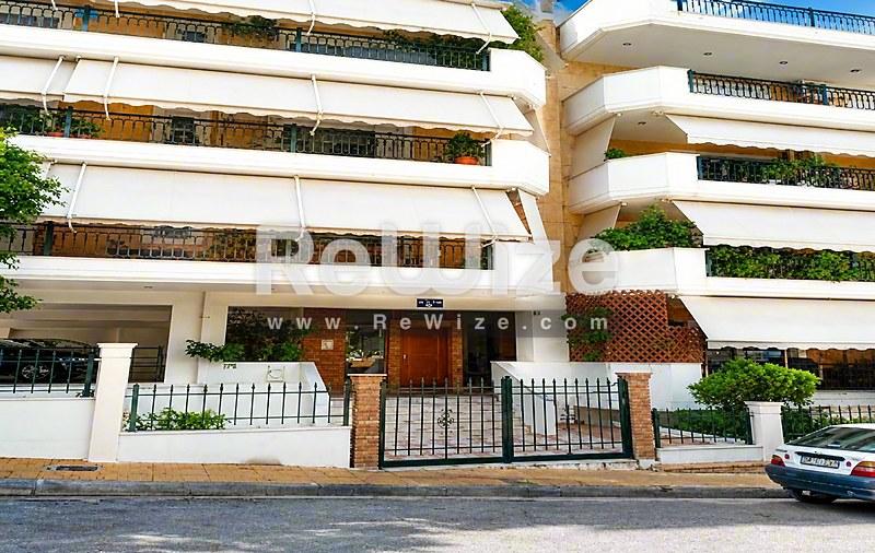 Σύγχρονη πολυκατοικία στη Χαλκιδική με καμπύλα μπαλκόνια και πλούσια πράσινη βλάστηση.