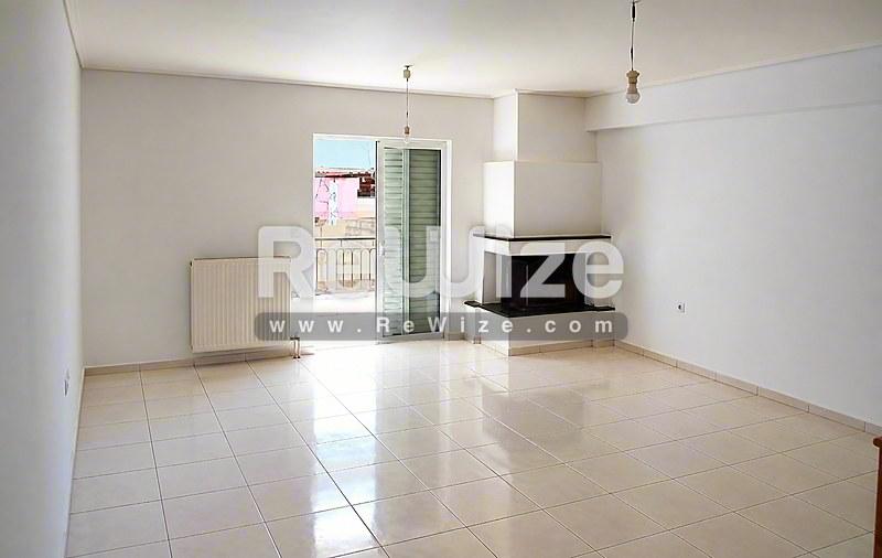 Φωτεινό σαλόνι του ακινήτου rw-7618 στη Χαλκιδική με σύγχρονα πλακάκια και τζάκι.