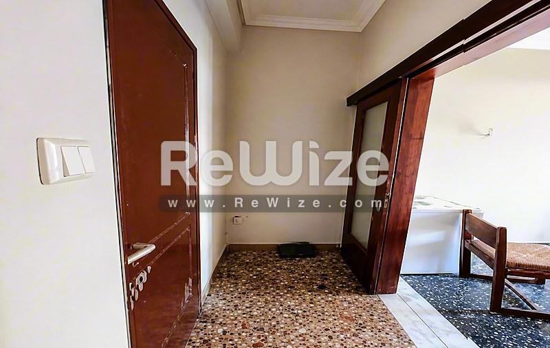Διάδρομος του διαμερίσματος rw-7622 στη Χαλκιδική με τερακότα πόρτες και παραδοσιακό πλακόστρωτο δάπεδο.