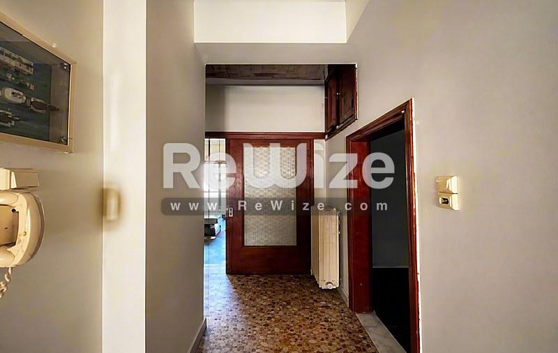 Διάδρομος του ακινήτου rw-7622 στη Χαλκιδική με ξύλινες πόρτες, κρεμ τοίχους και φελλό δάπεδο.