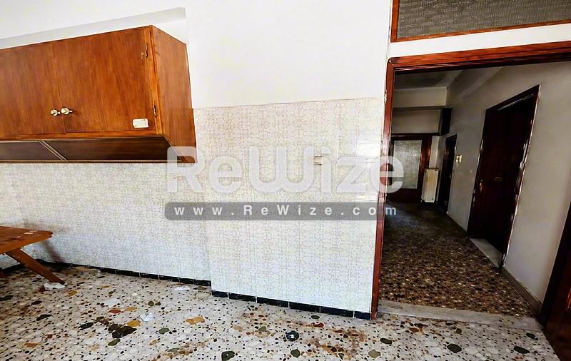 Ευρύχωρη κουζίνα στο ακίνητο Halkidiki rw-7622 με δάπεδο terrazzo και ξύλινα έπιπλα.