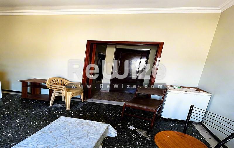 Σαλόνι του rw-7622 στη Χαλκιδική με σκούρο δάπεδο, ξύλινα έπιπλα και ουδέτερες αποχρώσεις τοίχων.