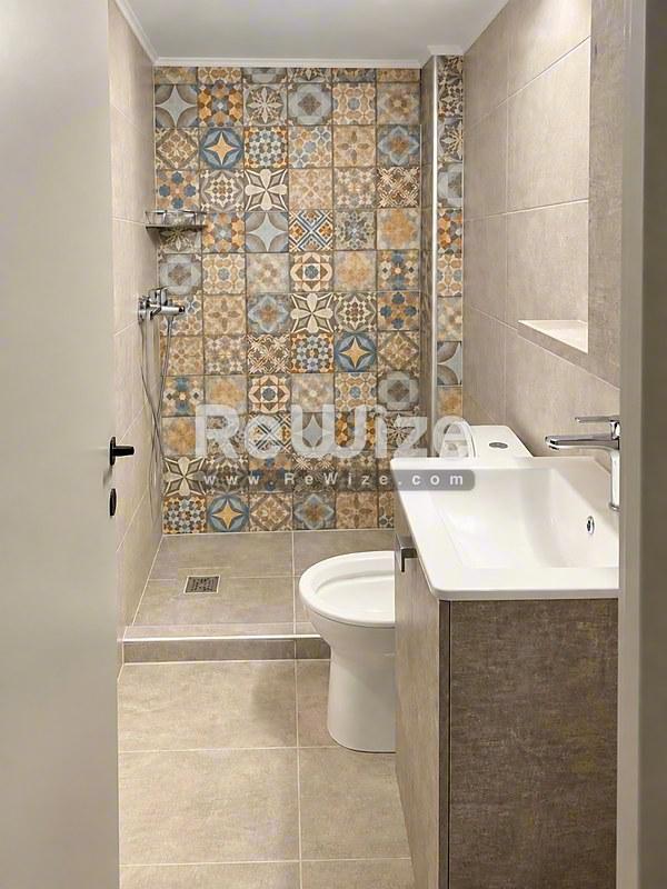 Σύγχρονο μπάνιο στο διαμέρισμα Halkidiki rw-7625 με διακοσμητικά πλακάκια και σύγχρονα είδη.