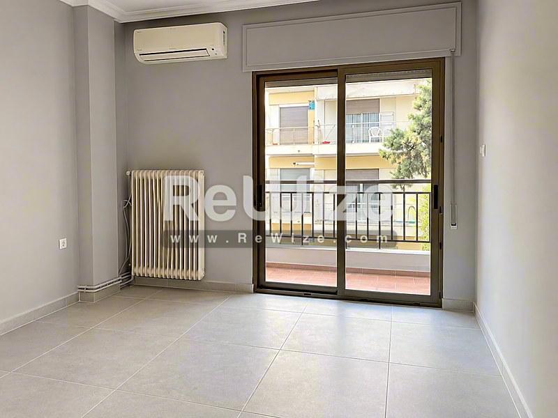 Φωτεινό σαλόνι διαμερίσματος στη Χαλκιδική με θύρες μπαλκονιού και σύγχρονες ανέσεις.
