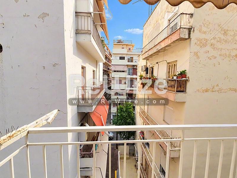 Θέα από το μπαλκόνι του ακινήτου rw-7626 στη Χαλκιδική με θέα σε γειτονικά κτίρια και μεσογειακές οδούς.