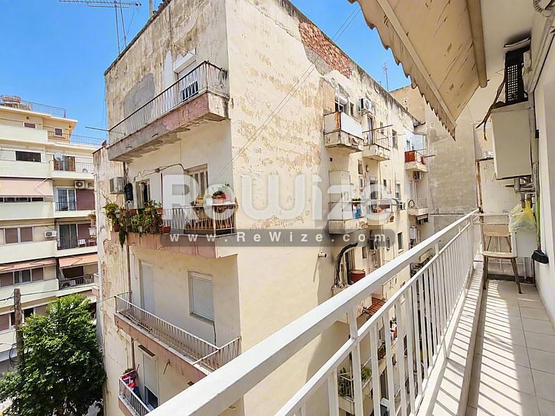 Ευρύχωρο μπαλκόνι του διαμερίσματος rw-7626 στη Χαλκιδική με θέα στα γειτονικά κτίρια.