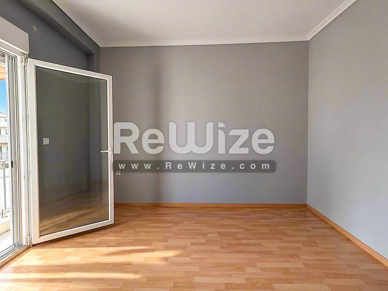 Φωτεινό σαλόνι στο ακίνητο Halkidiki rw-7626 με ξύλινο δάπεδο και σύγχρονες γυάλινες πόρτες.