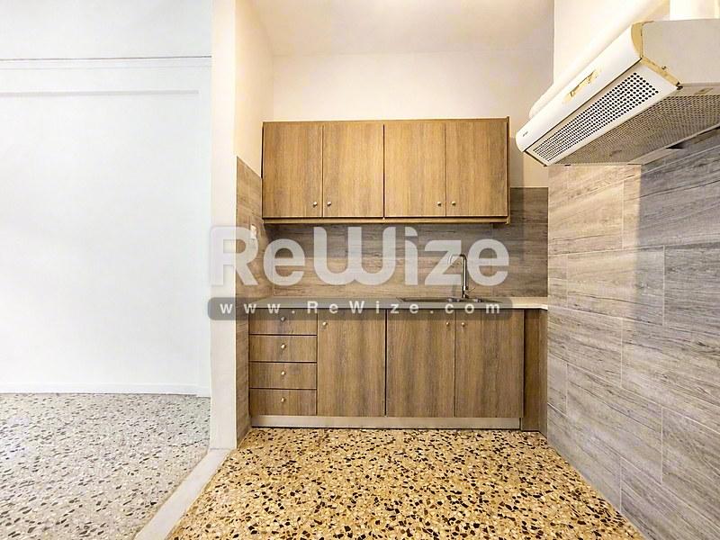 Μικρή κουζίνα με ξύλινα ντουλάπια και πέτρινο backsplash στο ακίνητο Halkidiki rw-7696.