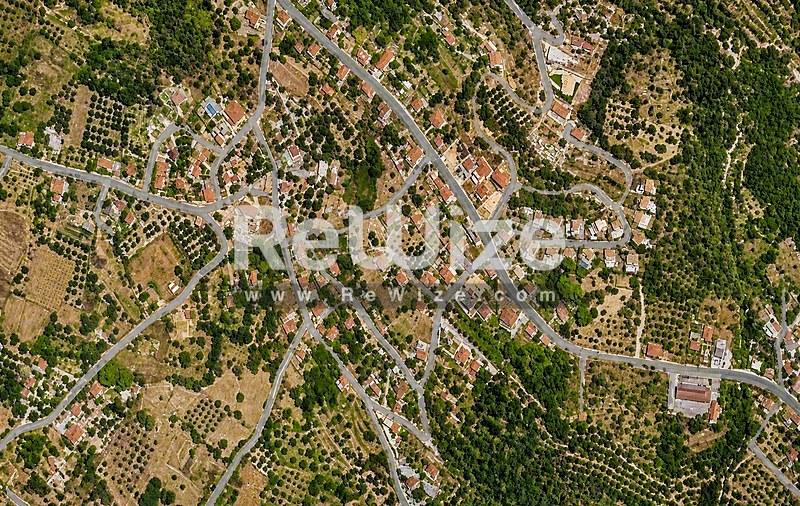 Αεροφωτογραφία οικοπέδου στη Χαλκιδική περιτριγυρισμένου από πράσινη βλάστηση και γειτονικές ιδιοκτησίες.