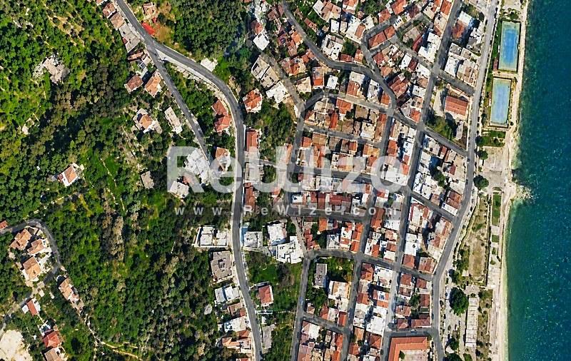 Αεροφωτογραφία κατοικίας στη Χαλκιδική ανάμεσα σε πυκνό δάσος και τυρκουάζ θάλασσα.