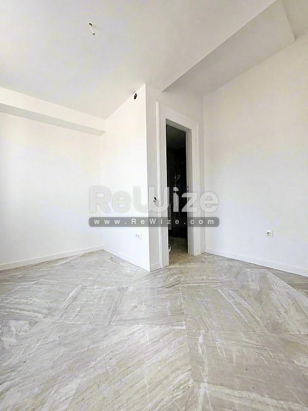 Ευρύχωρο σαλόνι σε σύγχρονο ακίνητο στη Χαλκιδική rw-7710 με ξύλινο δάπεδο και λευκά τοίχο.