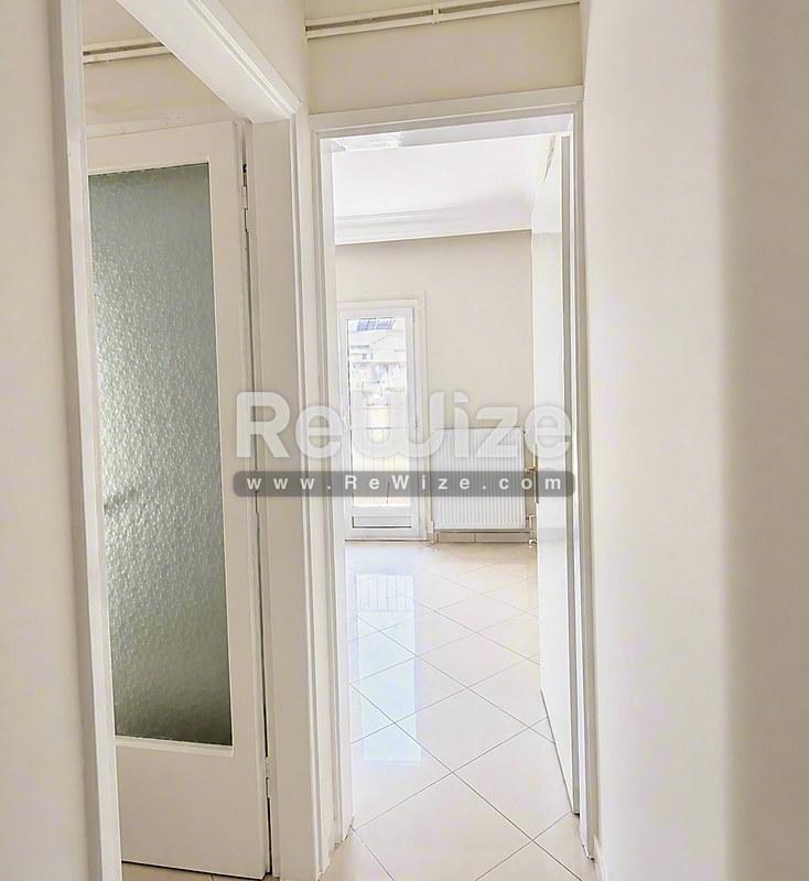 Φωτεινός διάδρομος του ακινήτου rw-7712 στη Χαλκιδική με λευκές πόρτες και πλακόστρωτο δάπεδο.