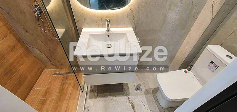 Σύγχρονο μπάνιο στο ακίνητο Halkidiki rw-7713 με λευκό νιπτήρα, τουαλέτα και πλακάκια.