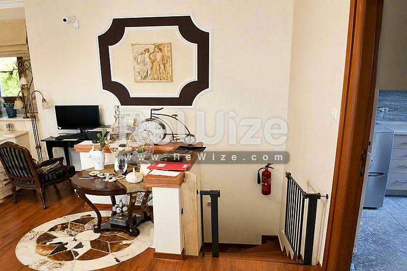 Φωτεινή είσοδος σκάλας σε μονοκατοικία προς πώληση στη Χαλκιδική με ξύλινο δάπεδο.