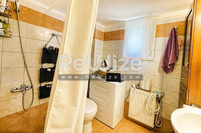Φωτεινό μπάνιο μεζονέτας στη Χαλκιδική με πλακάκια, καμπίνα ντουζ και σύγχρονα είδη.