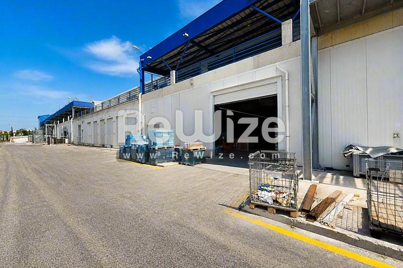Σύγχρονη βιομηχανική κατασκευή στη Χαλκιδική με μεγάλες πόρτες φόρτωσης και αποθηκευτικά υλικά.