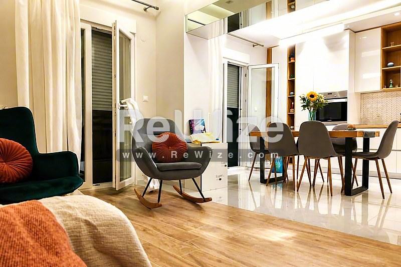 Σύγχρονο διαμέρισμα ανοιχτής διαρρύθμισης στη Χαλκιδική με просторο χώρο διαβίωσης, ξύλινο δάπεδο και άνετη σύνδεση μεταξύ σαλονιού και τραπεζαρίας.