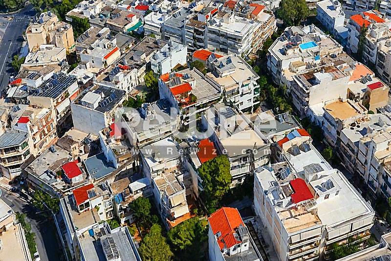 Εναέρια άποψη διαμερίσματος στη Χαλκιδική περιτριγυρωμένου από κατοικίες και δενδροφυτεμένους δρόμους.