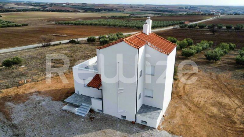 Εναέρια άποψη σύγχρονης μονοκατοικίας με κεραμοσκεπή στη Χαλκιδική, περιστοιχισμένη από γεωργικές εκτάσεις.