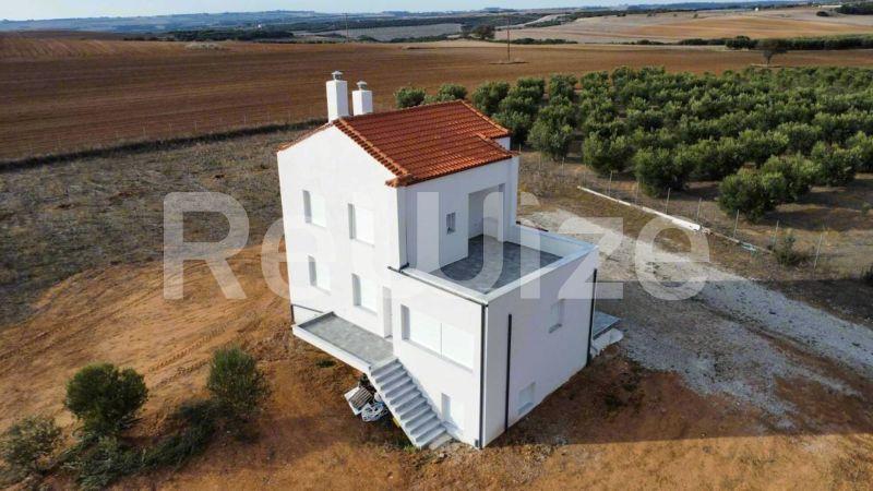 Εναέρια άποψη σύγχρονης μονοκατοικίας με κόκκινη στέγη στη Χαλκιδική, περιτριγυρισμένη από γεωργικές εκτάσεις.