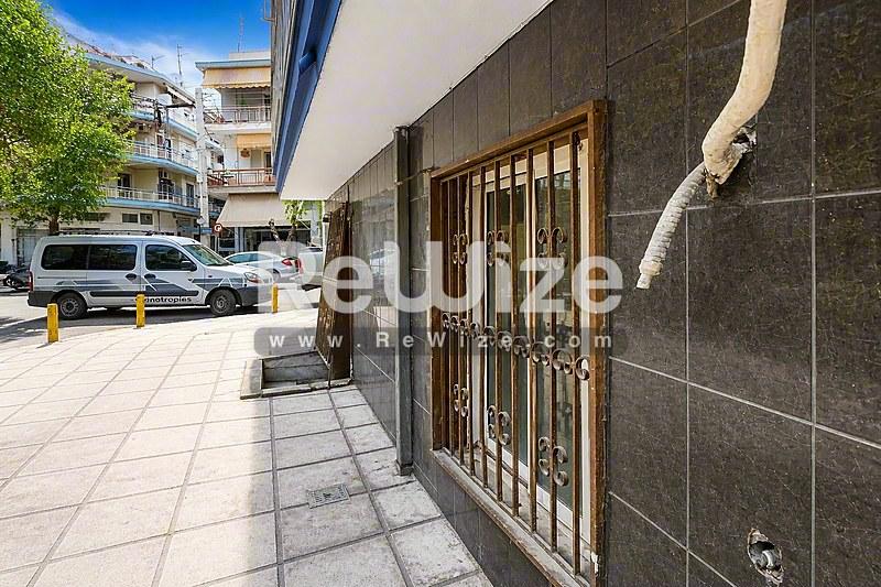 Σύγχρονη πρόσοψη καταστήματος με σκούρα πλακάκια και μεταλλικές πόρτες στη Χαλκιδική.
