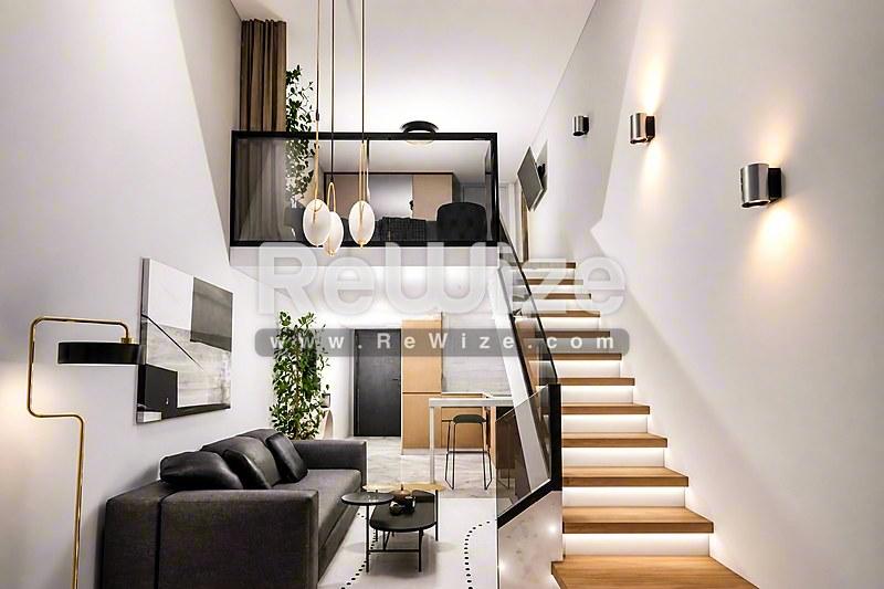 Σύγχρονο loft στη Χαλκιδική με διπλό ύψος, μαύρο δερμάτινο καναπέ, ξύλινη σκάλα και σύγχρονο φωτισμό.