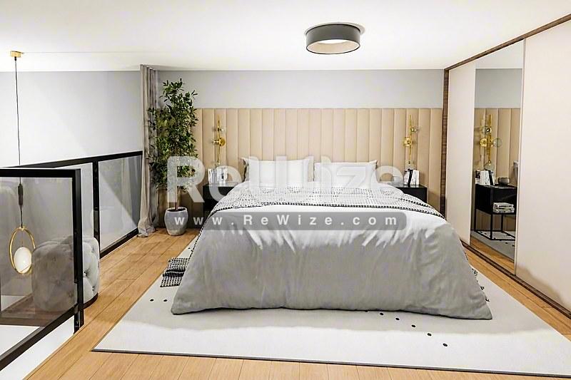 Σύγχρονο master bedroom σε loft της Χαλκιδικής με γκρι κρεβάτι, ξύλινο δάπεδο και ενσωματωμένη ντουλάπα.