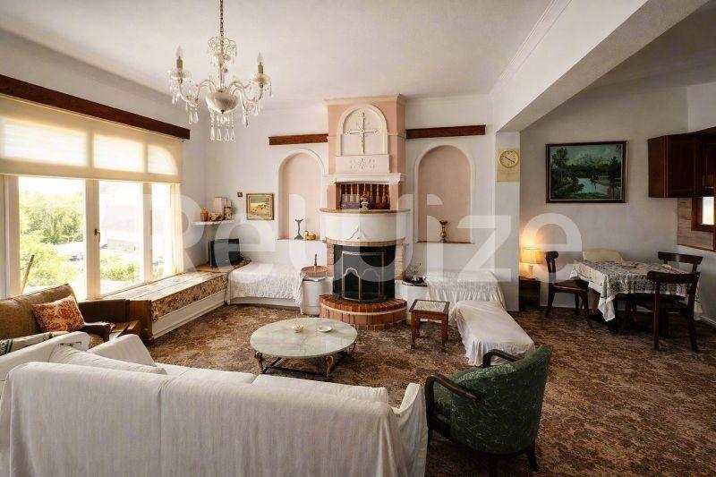 Κομψό σαλόνι μονοκατοικίας στην Χαλκιδική με τζάκι, πολυέλαιο και κλασικά έπιπλα.