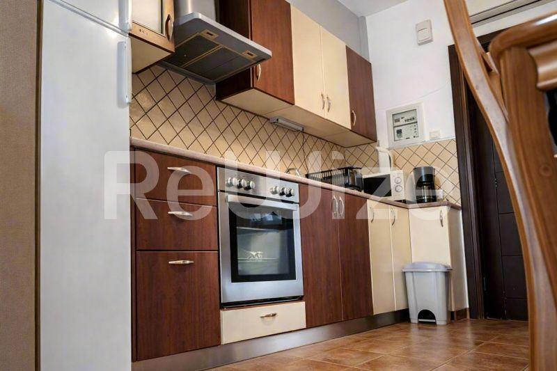 Σύγχρονη εξοπλισμένη κουζίνα μεζονέτας στη Χαλκιδική με ξύλινα ντουλάπια και ενσωματωμένο φούρνο.