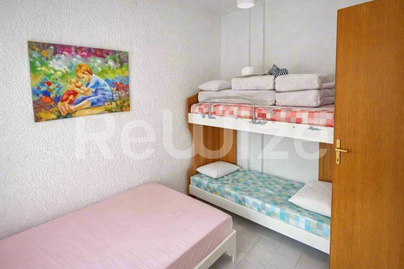 Συμπαγό υπνοδωμάτιο μεζονέτας στη Χαλκιδική με κρεβάτια κουκέτα, ροζ κρεβάτι και ξύλινη ντουλάπα.