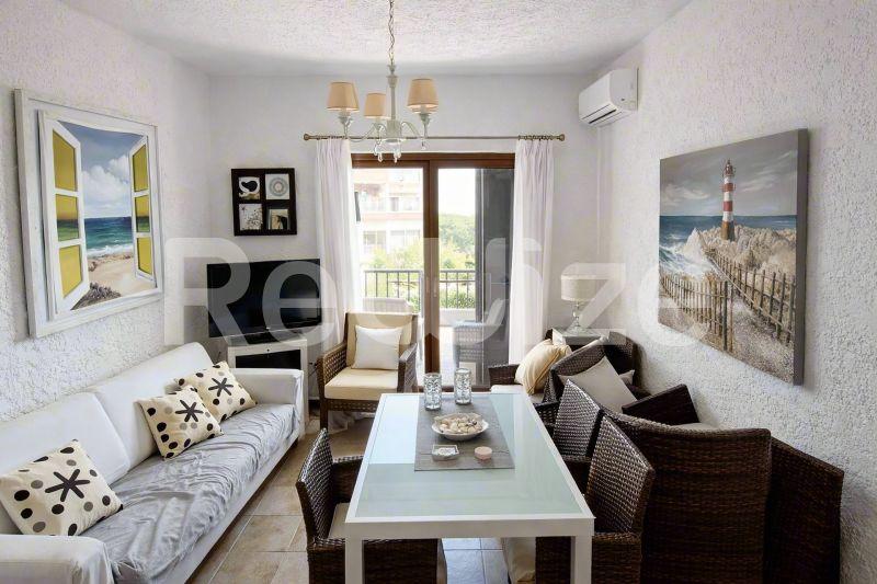 Φωτεινή τραπεζαρία μεζονέτας στη Χαλκιδική με λευκό τραπέζι, άνετη καθιστική και πρόσβαση σε μπαλκόνι.