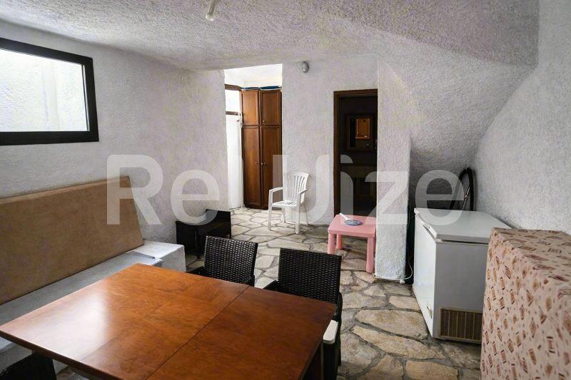 Σαλόνι μεζονέτας στη Χαλκιδική με ξύλινο τραπέζι τραπεζαρίας, έπιπλα αποθήκευσης και πρόσβαση σε υπνοδωμάτια.