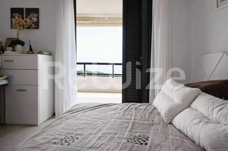 Φωτεινό master bedroom μεζονέτας στη Χαλκιδική με μπαλκόνι θέας θάλασσας, σύγχρονα έπιπλα και φυσικό φως.