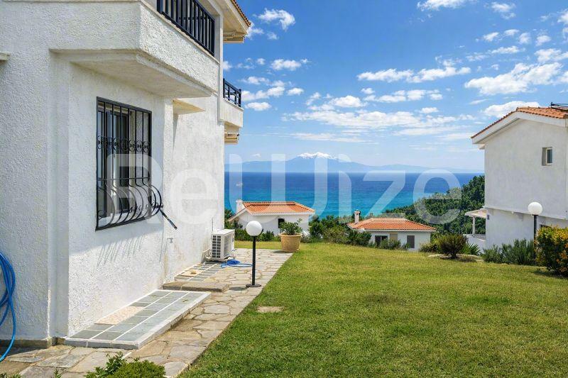 Θέα θάλασσας από μεζονέτα στη Χαλκιδική με γαλάζια νερά και πράσινο κήπο.