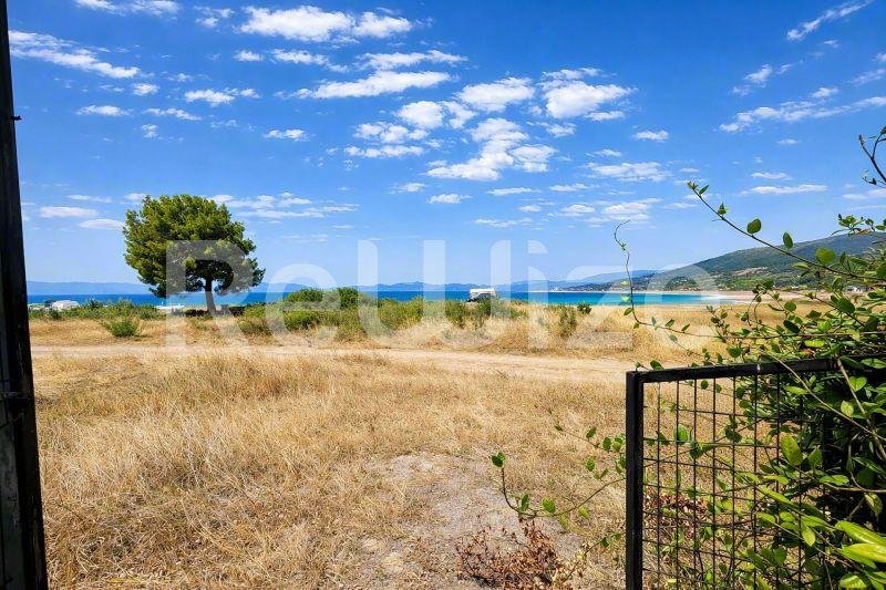 Θέα θάλασσας από ένα μονοκατοικία στη Χαλκιδική με θέα σε αμμώδη παραλία και γαλάζια νερά.