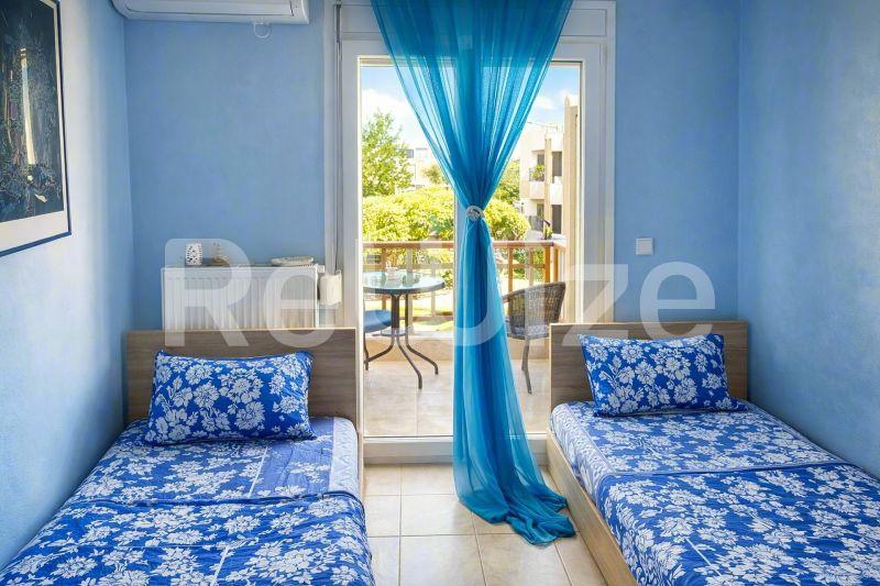 Φωτεινή δίκλινη κρεβατοκάμαρα μεζονέτας στη Χαλκιδική με μπλε διακόσμηση.