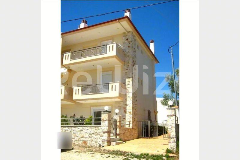 Πρόσοψη σύγχρονης μεζονέτας στη Χαλκιδική, Κασσάνδρα, με κίτρινες τοιχοποιίες και μπαλκόνια.