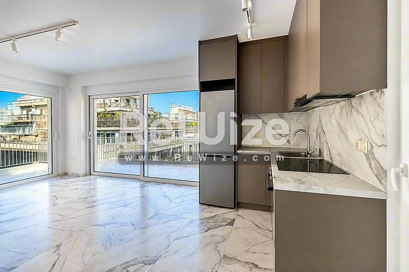 Μοντέρνα κουζίνα με μάρμαρο σε διαμέρισμα της Χαλκιδικής με κομψά ντουλάπια και άφθονο φυσικό φως.