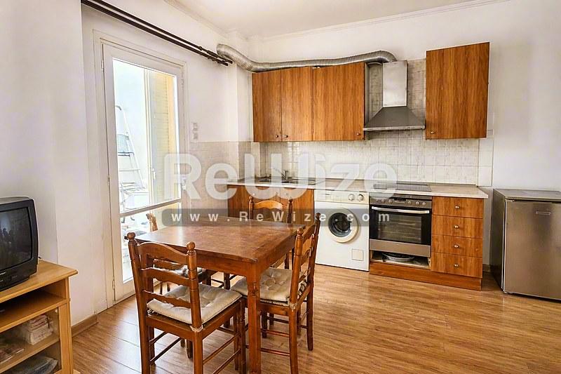 Φωτεινή κουζίνα διαμερίσματος στη Χαλκιδική με ξύλινα ντουλάπια και σύγχρονες συσκευές.