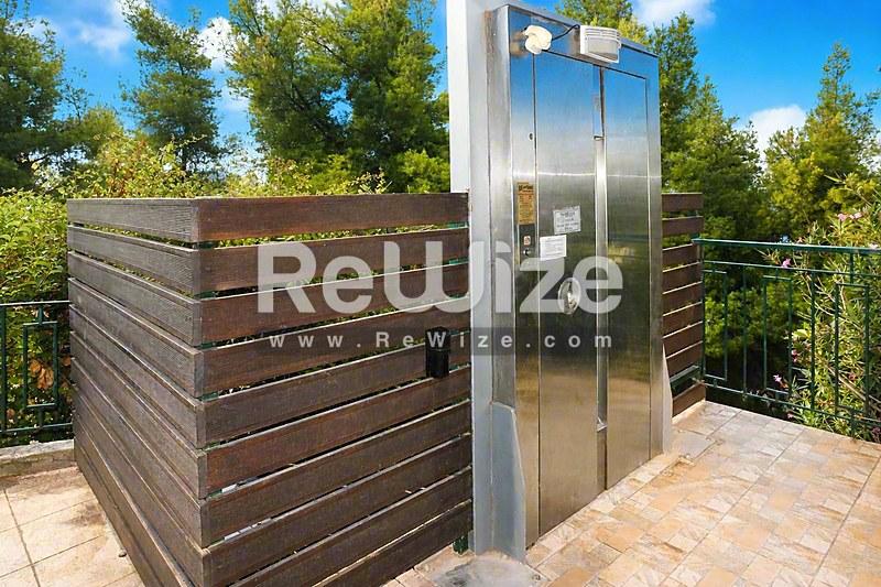 Σύγχρονη εξωτερική κουζίνα με inox εξοπλισμό και ξύλινα διαχωριστικά σε μεζονέτα της Χαλκιδικής.