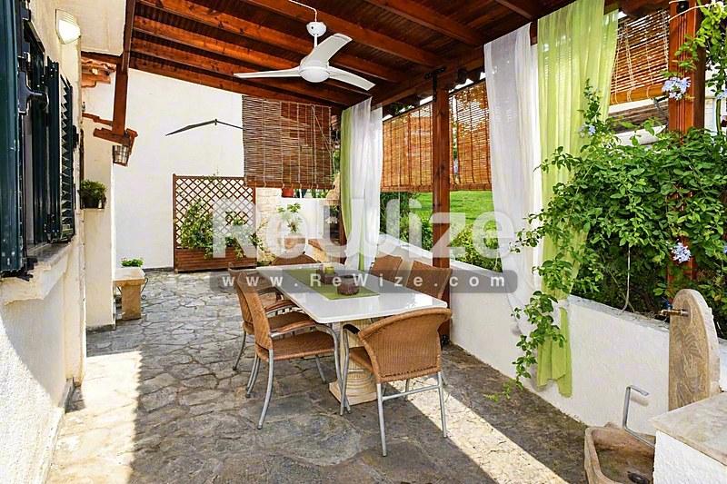 Σκιασμένη βεράντα περγκόλας μεζονέτας στη Χαλκιδική με τραπέζι και φυτά.