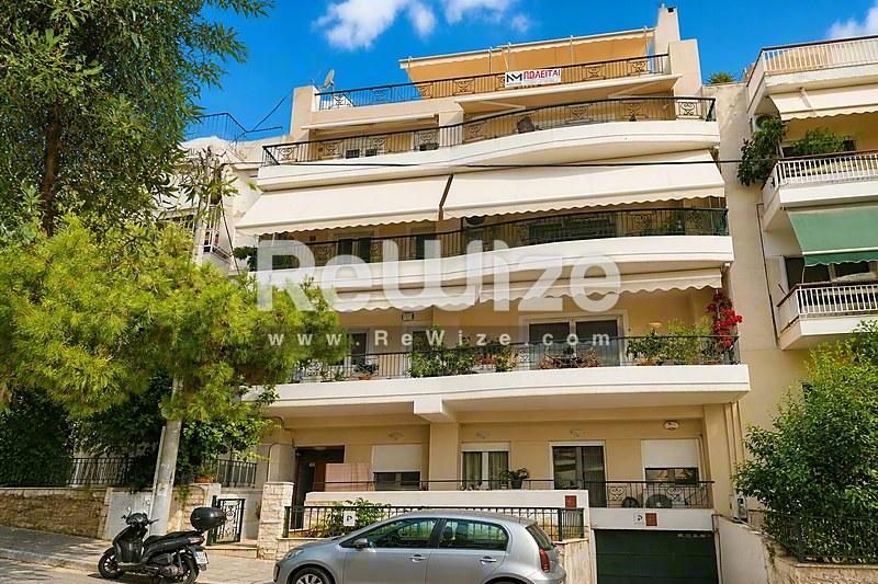 Σύγχρονη διαμέρισμα με πολλαπλά μπαλκόνια στη Χαλκιδική, με λευκή αρχιτεκτονική και πράσινο περιβάλλον.