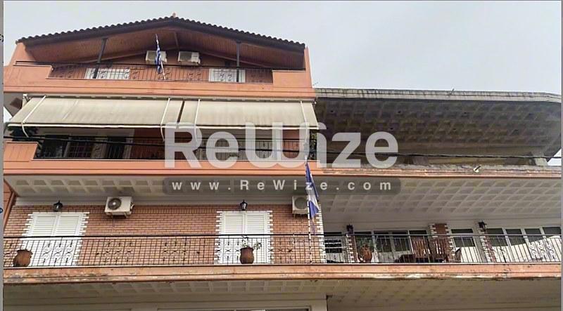 Πρόσοψη διαμερίσματος από τούβλο στη Χαλκιδική με πολλαπλά μπαλκόνια και κλιματιστικές μονάδες.