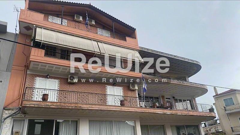 Πρόσοψη διαμερίσματος κατοικίας στη Χαλκιδική με τούβλινη όψη και πολλαπλά μπαλκόνια.