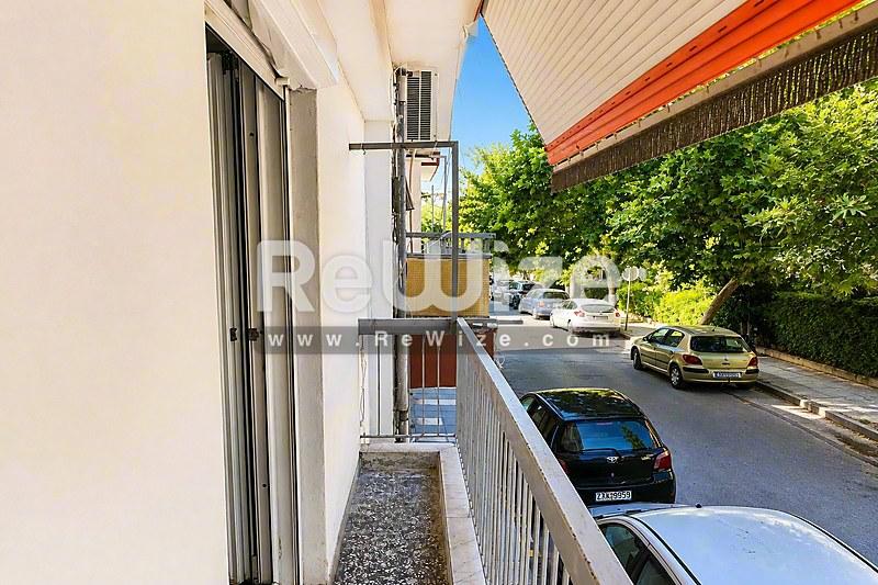 Ηλιόλουστο μπαλκόνι διαμερίσματος στη Χαλκιδική με θέα στο δρόμο και πράσινη περιοχή.