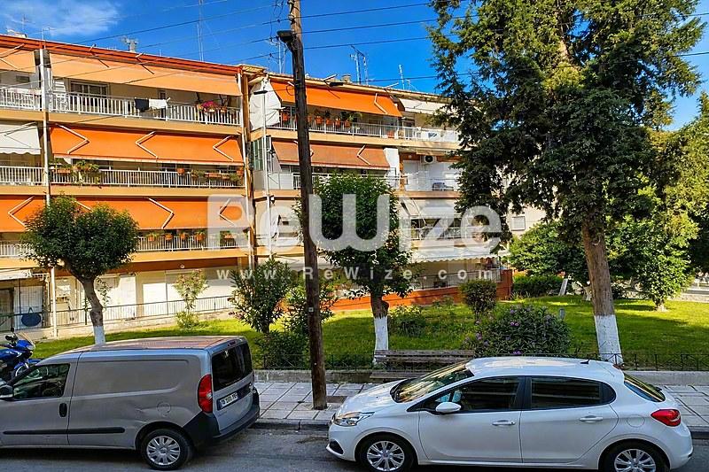 Σύγχρονη διαμέρισμα με πορτοκαλί διακόσμηση στη Χαλκιδική, με μπαλκόνια και δένδρα.