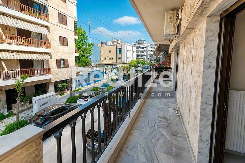 Ευρύχωρο μπαλκόνι διαμερίσματος στη Χαλκιδική με θέα γειτονικών κτιρίων και γαλάζιο ουρανό.