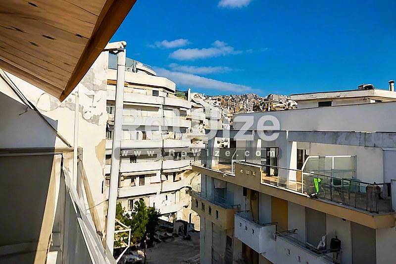 Θέα από το μπαλκόνι διαμερίσματος στη Χαλκιδική με γειτονικά κτίρια και βουνά.